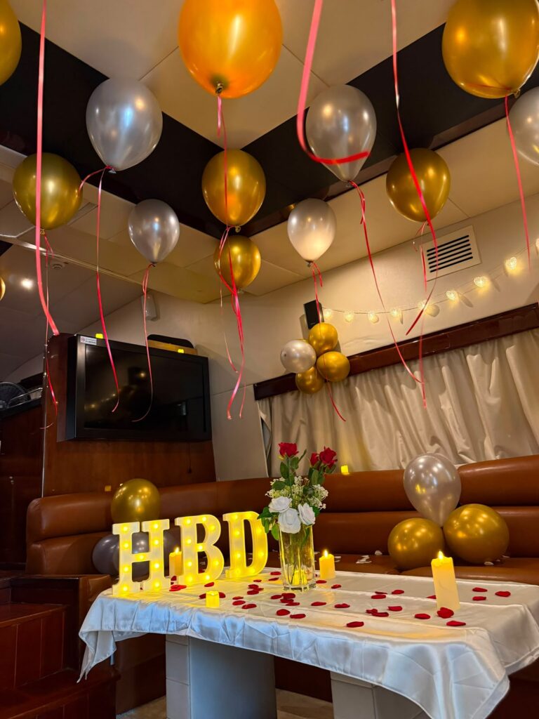 Birthday yacht table setup with HBD letters, candles and roses