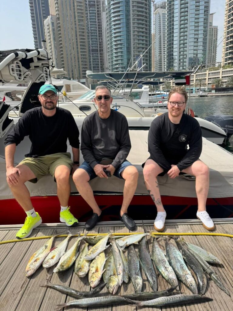 Guests sitting with their catch after a deep sea fishing trip at Dubai Marina