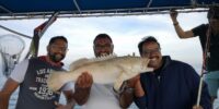 Group of anglers holding a grouper on a deep sea fishing trip in Dubai